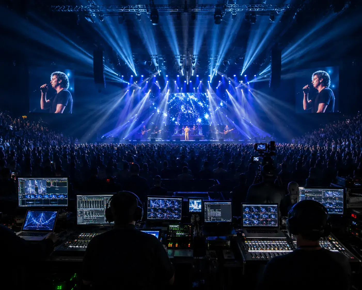 Indoor live concert with audience, stage lights, camera coverage, and production control area